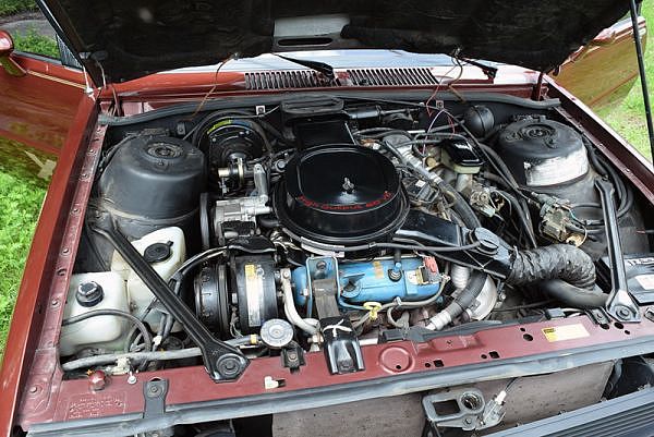 The engine and other parts under the hood of a Chevy Citation X-11