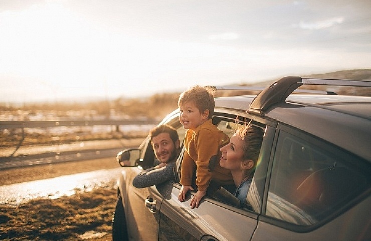 Photo of cute little family during their excursion with family car