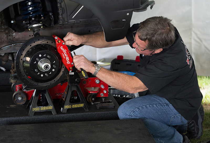 Randy Allgood, the owner of Kenwood Rod Shop, finishes the installation of Wilwood front brakes. The setup hauls it down with six-piston calipers and massive two-piece drilled and slotted rotors.