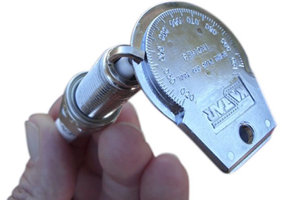 An old-school gap gauge is essential for spark plug replacement on vintage cars.