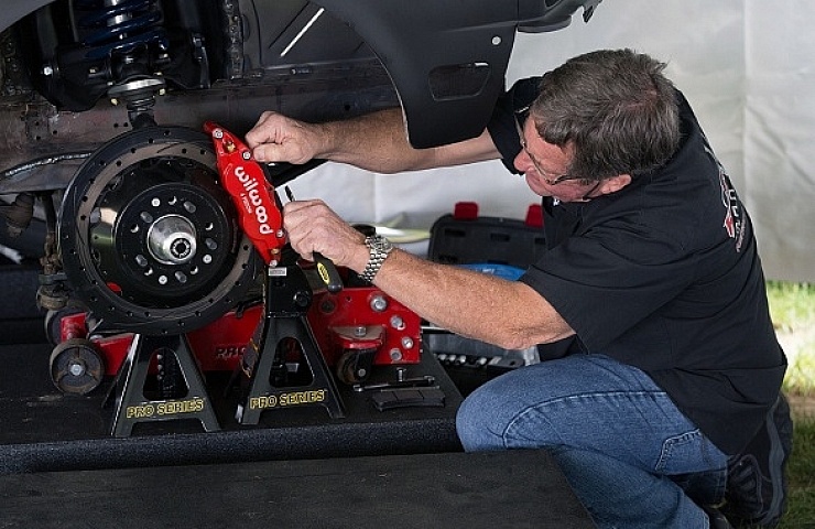 Randy Allgood works on the brakes of the eBay Motors 1967 Ford Mustang Fastback