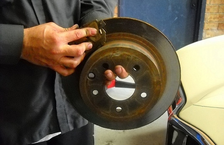 Mechanic holds brakes and pad