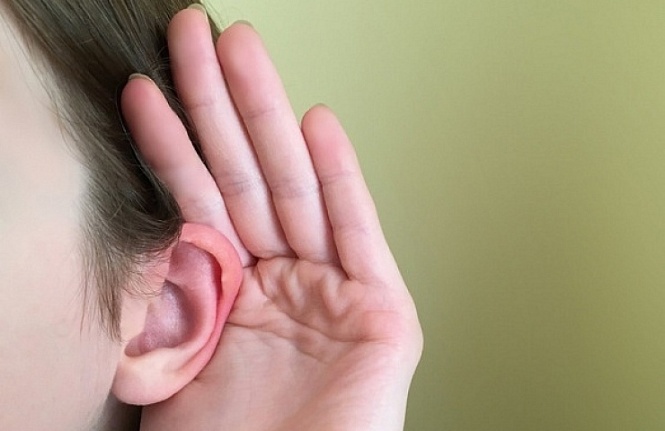 A woman carefully trying to hear something