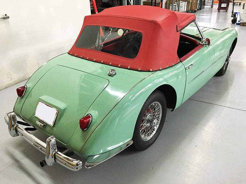 The car looks good in apple green, complementing a red vinyl soft top.