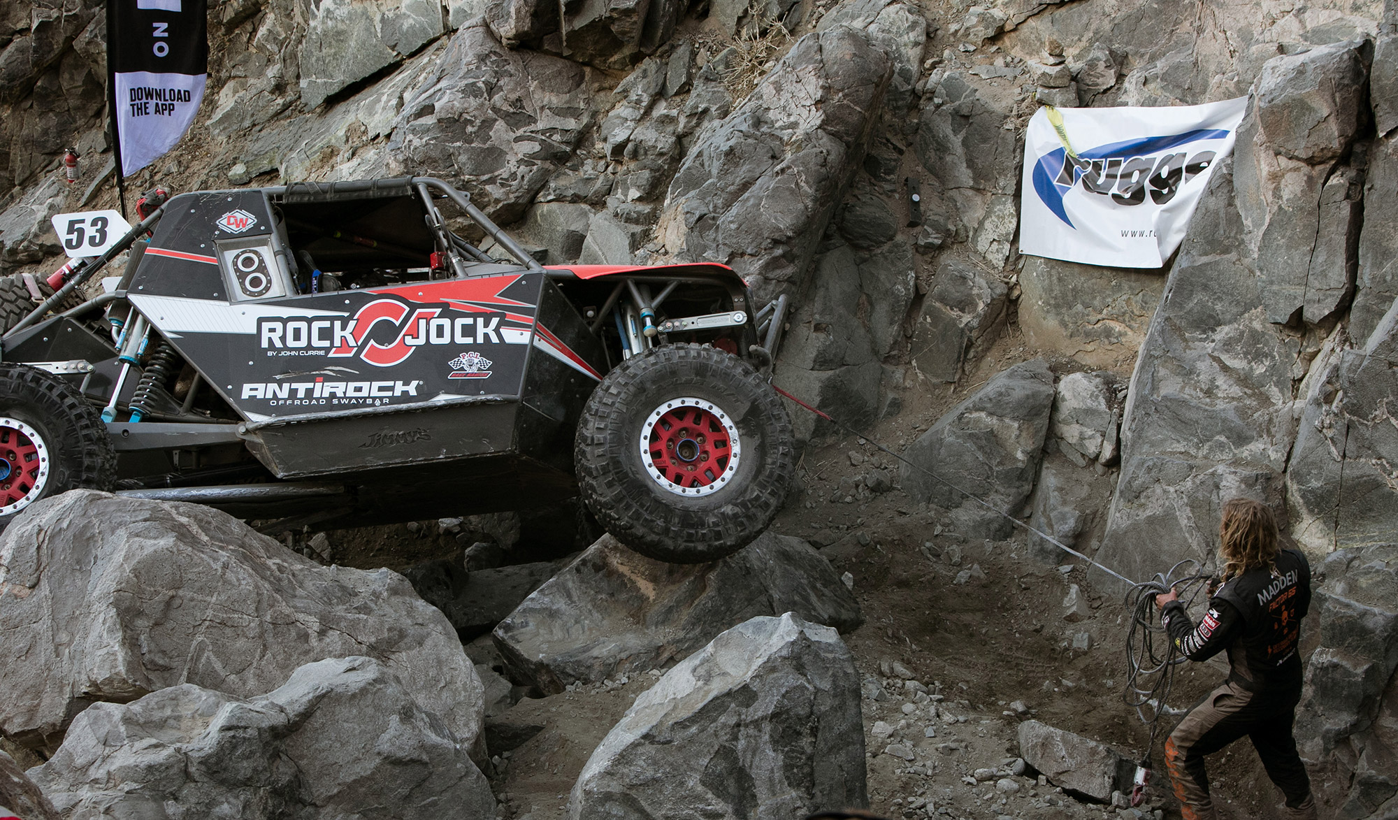 Co-driver Terry-Madden pulls the winch line so the RockJock Ultra4 car can through the Sledgehammer course.