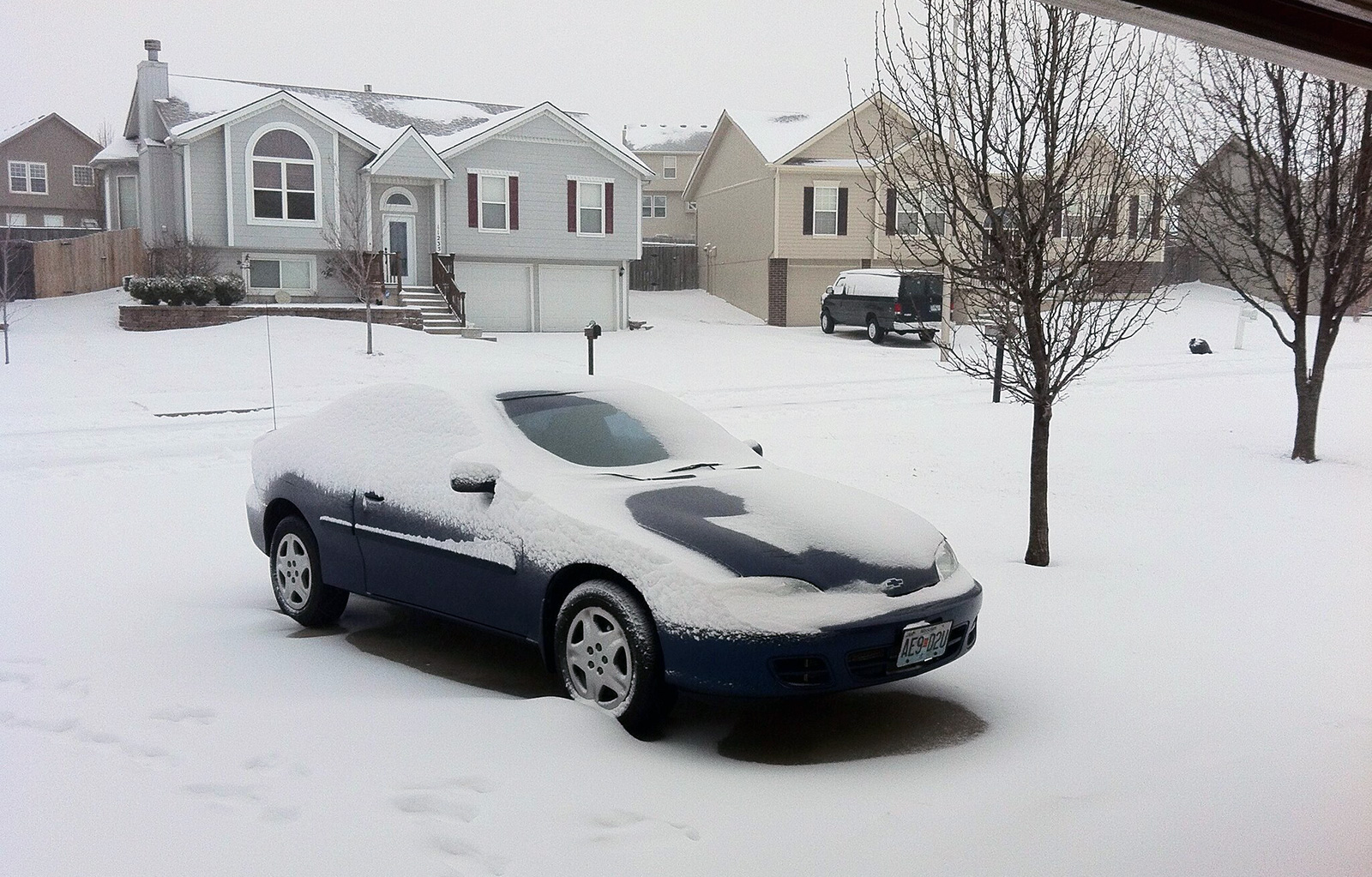 Snow covered car in the driveway
