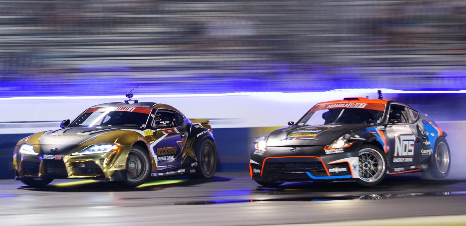Two cars drift racing on a track.