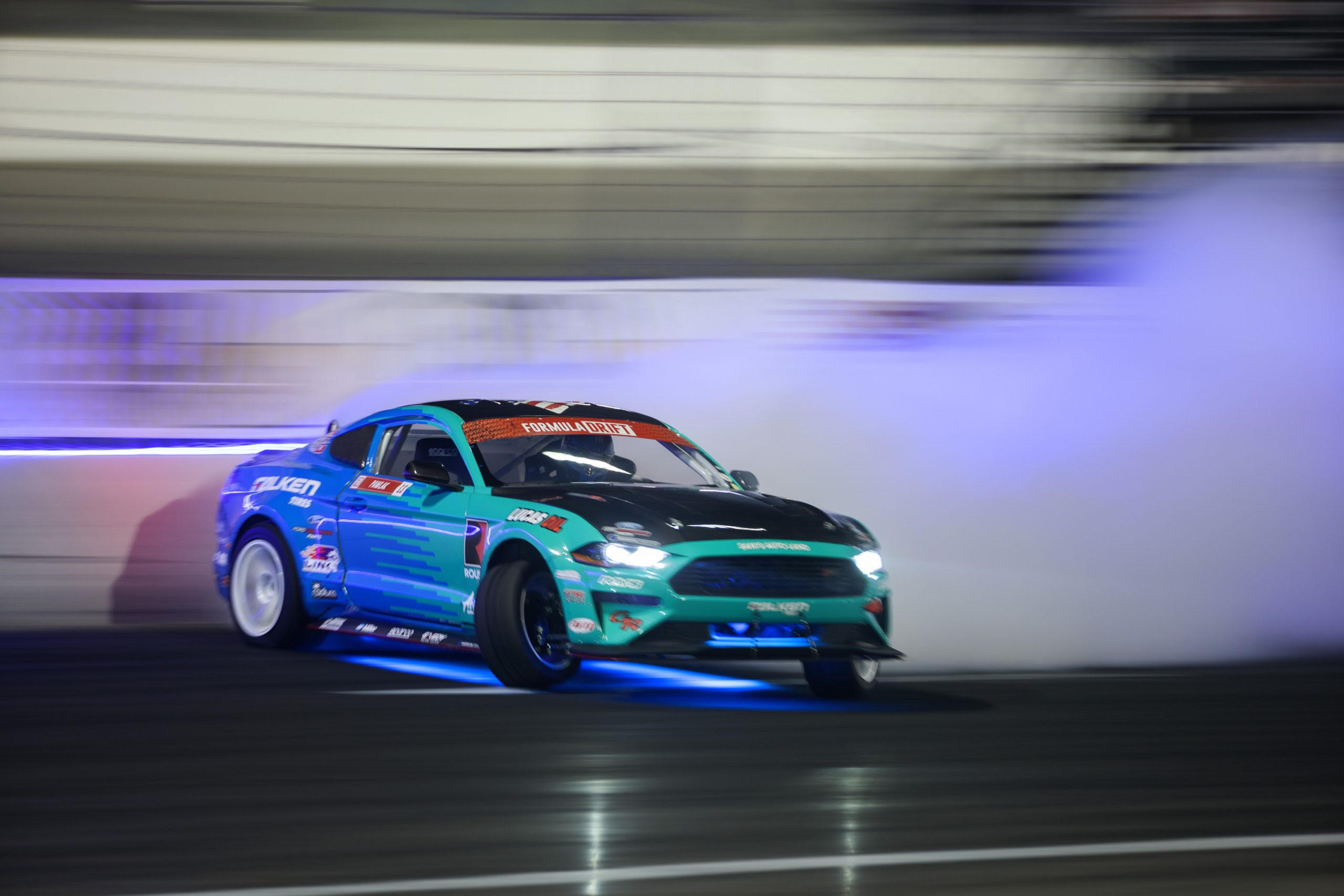 Justin Pawlak's Falken Tire Ford Mustang drifting on a racetrack