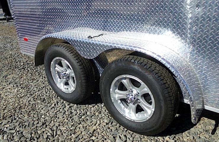 A diamond plate trailer with a pair of trailer tires on alloy wheels