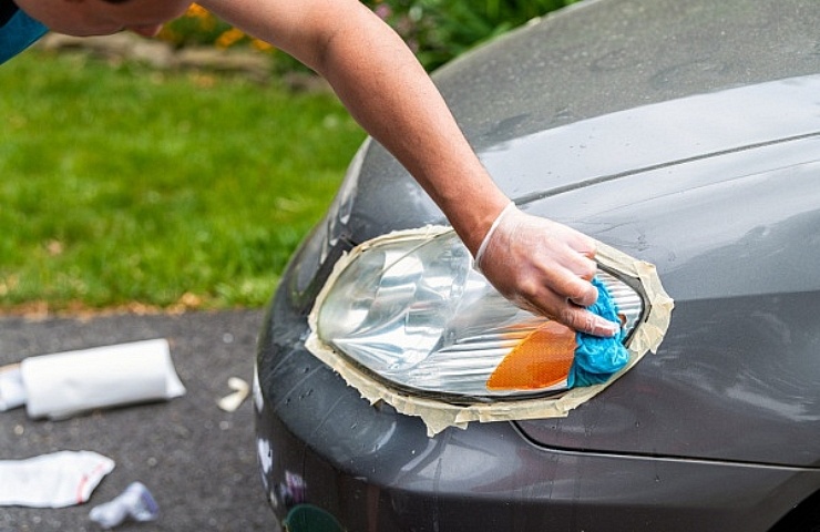 Man cleaning headlights