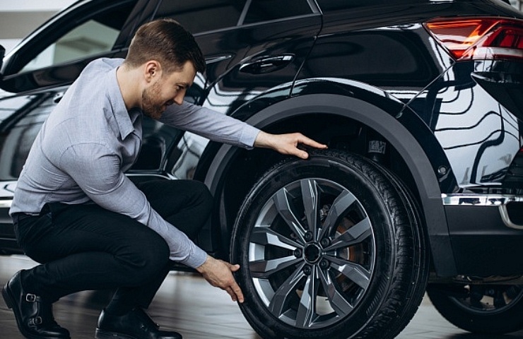 A shopper sizes up a car tire