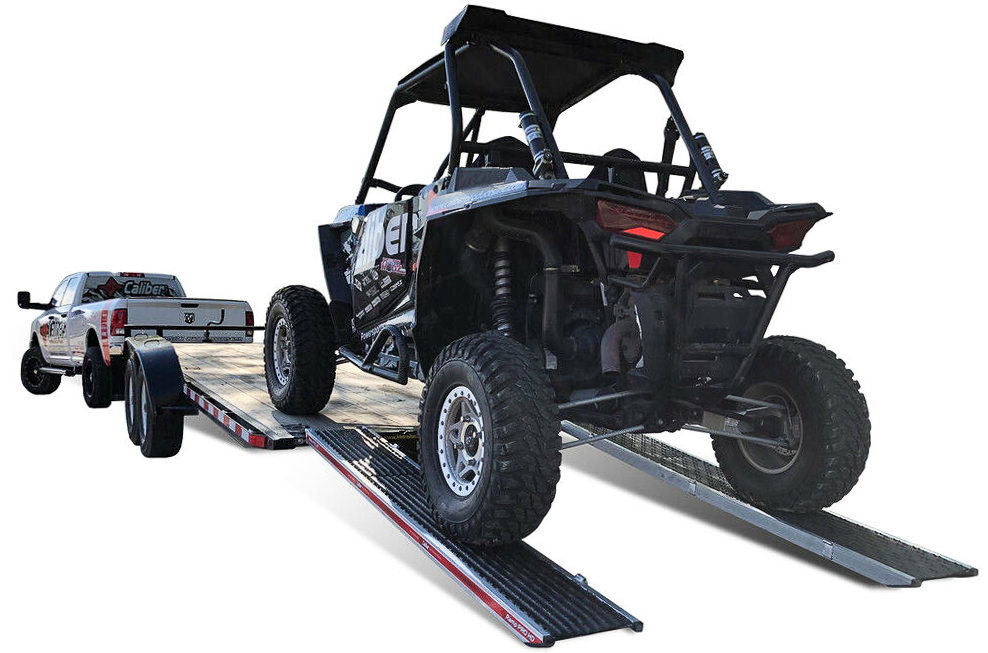 A sport UTV climbing Caliber ramps onto a trailer
