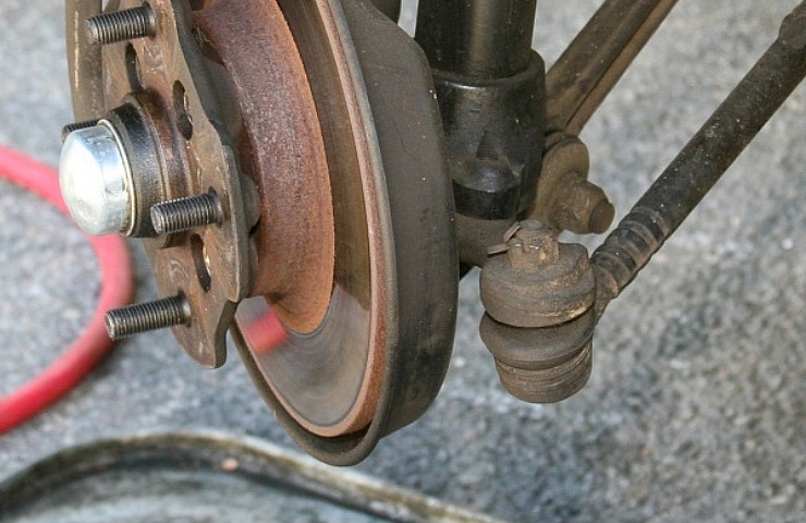 A worn outer tie rod end on a steering knuckle