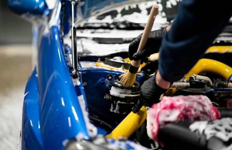 Cleaning engine bay with detailing brush