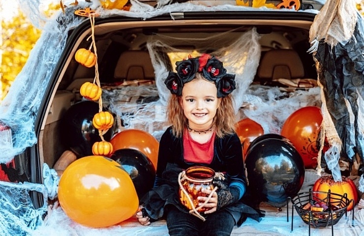 Trunk or treat! SUV with decorated cargo space, covered with cobwebs, and filled with pumpkins.