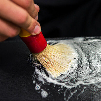 Brushing cleaner on a leather car seat