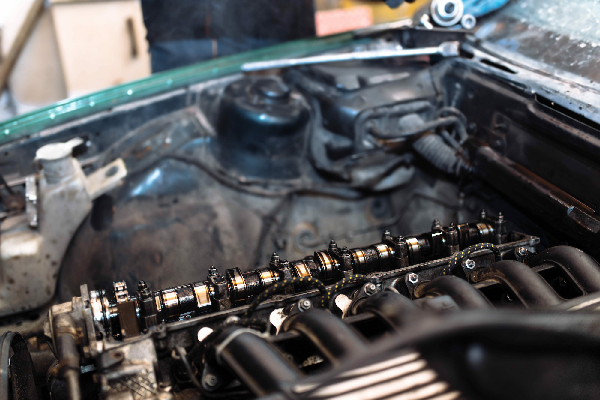 An inline-six cylinder engine with the valve cover off, exposing the camshaft.