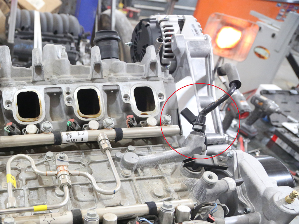 A PCV crankcase vent valve and connecting hose on a Gen V LT1 V-8 engine