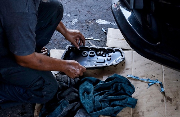 Auto mechanic with oil pan