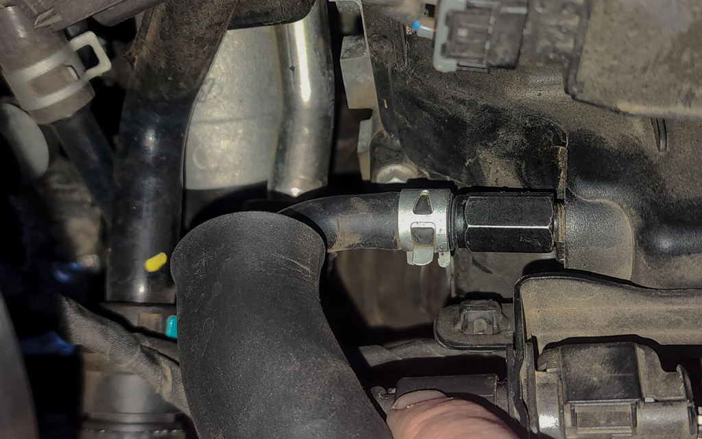 A closeup photo of a Kia Stinger car engine valve cover and crank vent