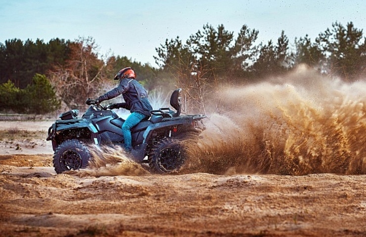 A racing ATV kicking up a plume of dirt