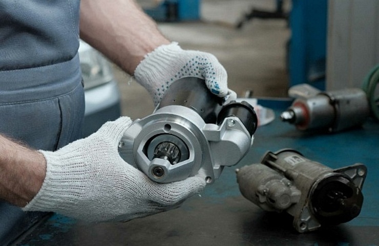 Car starter in the hands of a mechanic