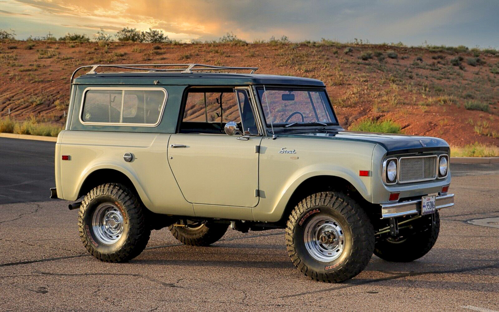 A 1970 International Harvester Scout 4x4 in the desert at sunset.