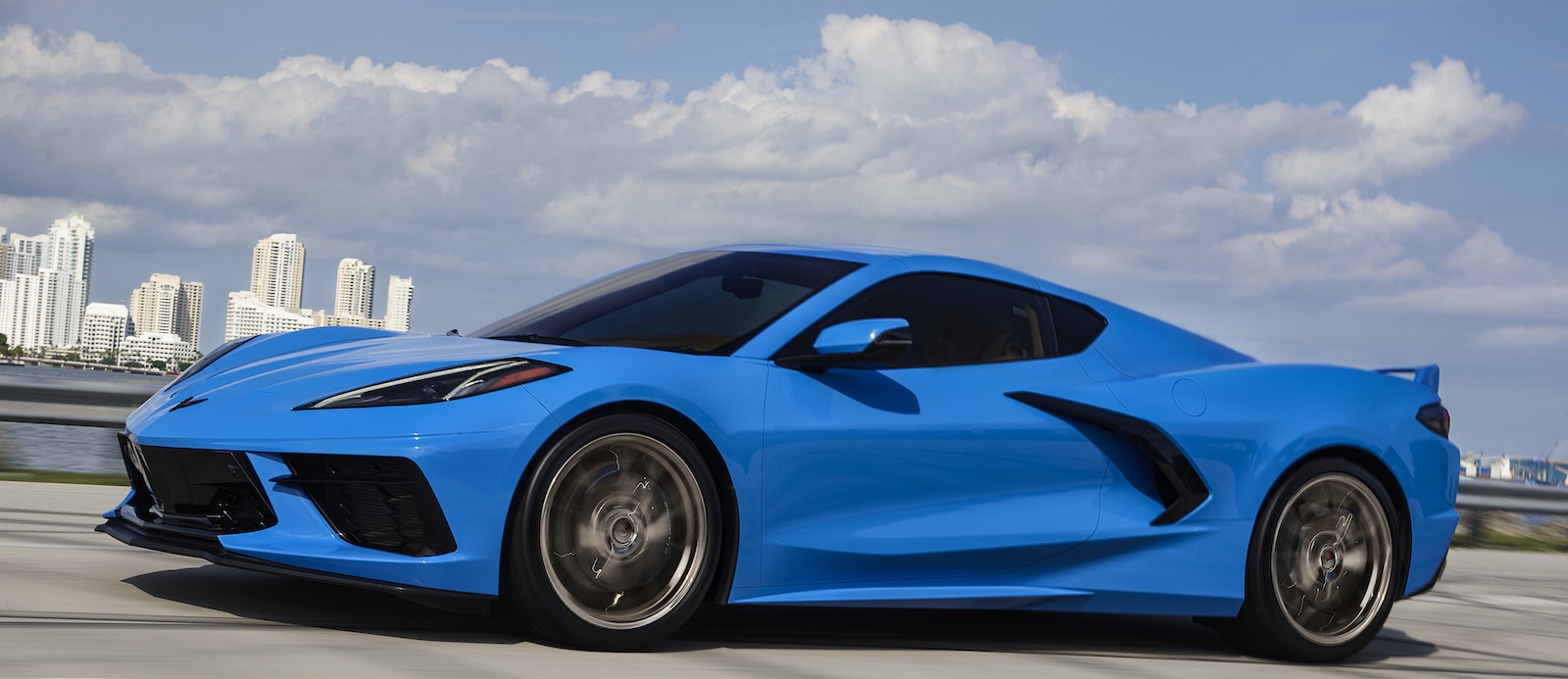 Mid-engine 2024 Chevrolet Corvette Stingray in Rapid Blue - side view - at speed