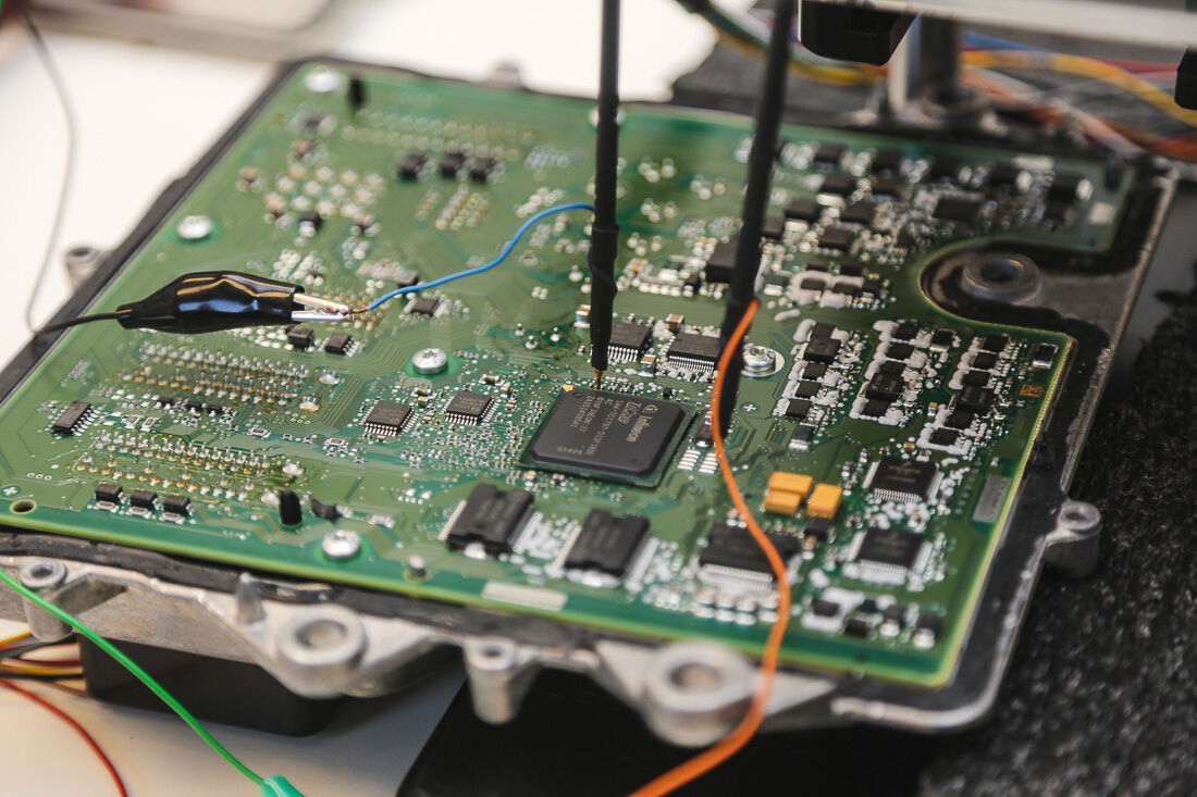 Two probes testing an ECU control board