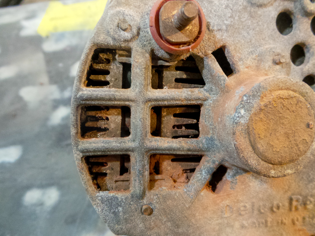 A close up of a used GM Delco Remy alternator that shows the internal voltage regulator