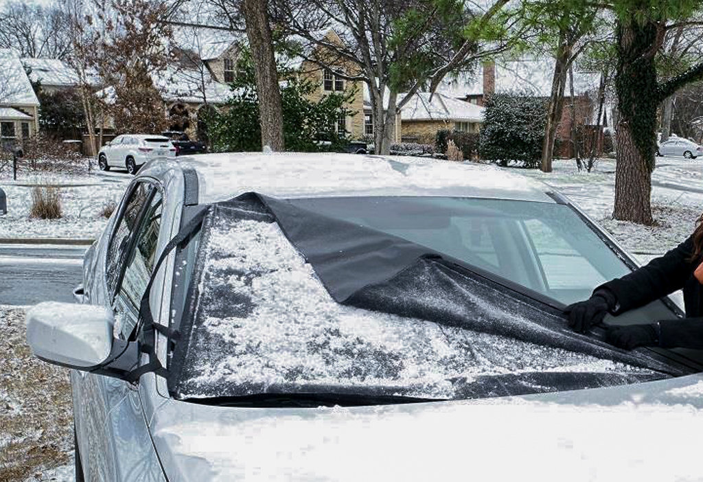A woman removing a Delk Frostguard windshield cover