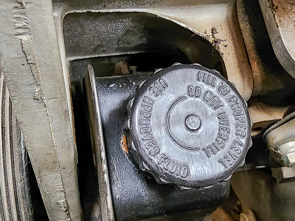 A power steering pump reservoir cap. 