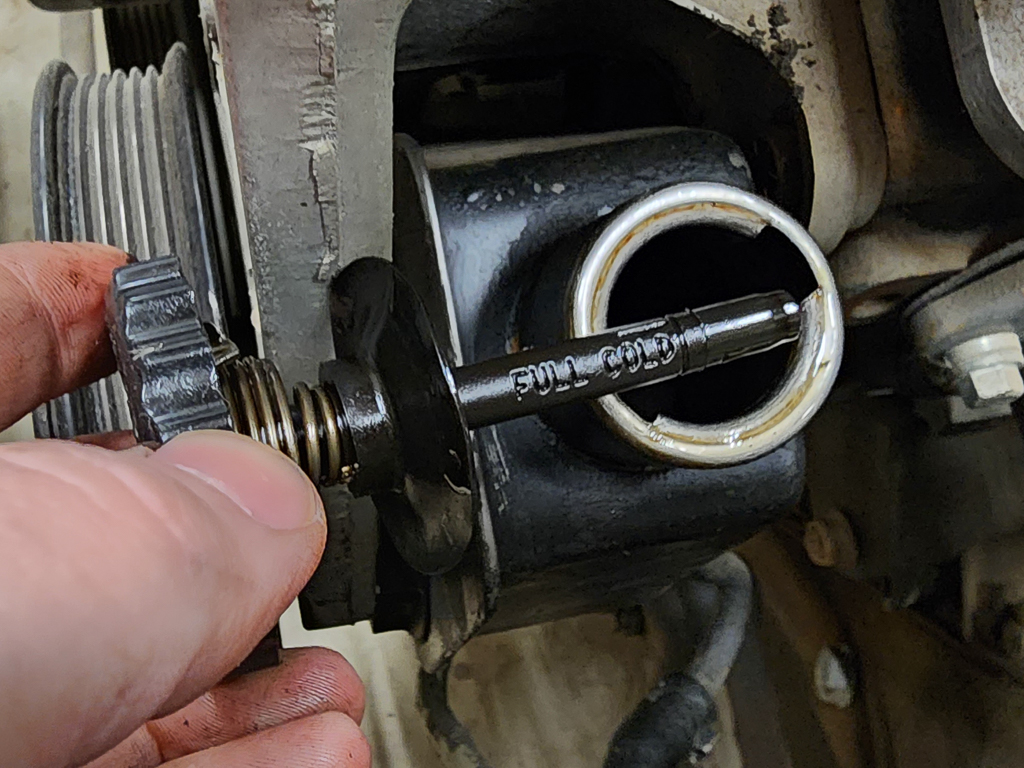 Checking power steering fluid level using a built in dipstick. 