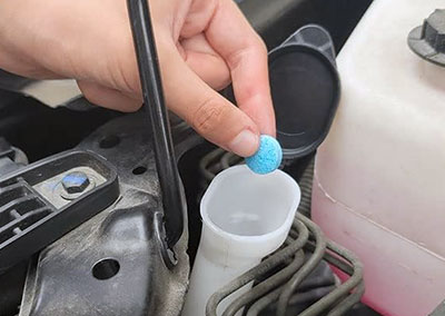 Adding a cleaning tablet to windshield wiper fluid