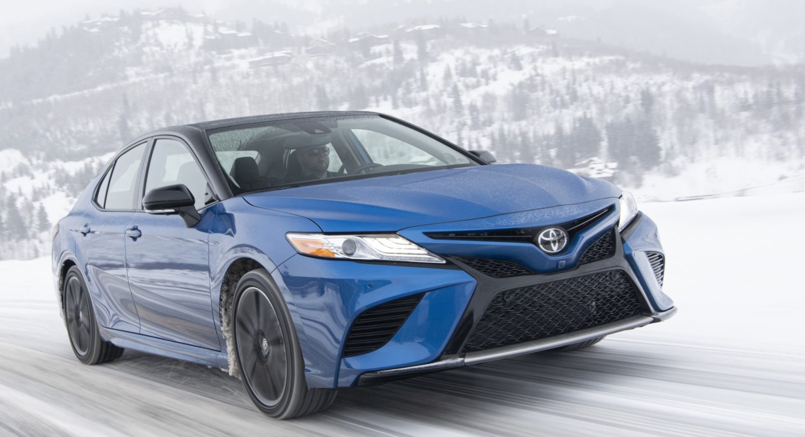 2020 Toyota Camry XSE AWD In Blue Streak Medtallic with a Midnight Black Metallic roof driving in snow