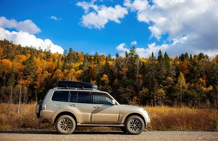 AWD or 4WD - SUV on gravel road in autumn - featured
