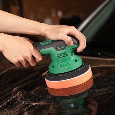 A woman operating a cordless car paint polisher