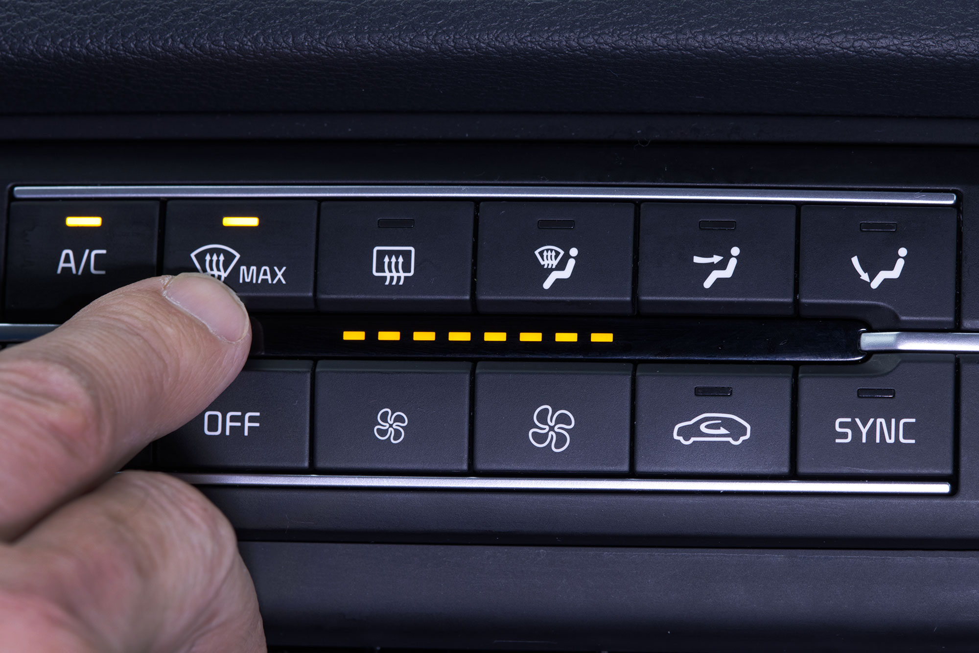 Hand pressing the defogger button to remove the fog on the windshield. 