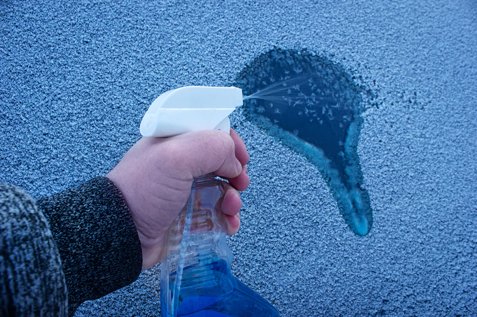 Defrosting windows with deicer spray.