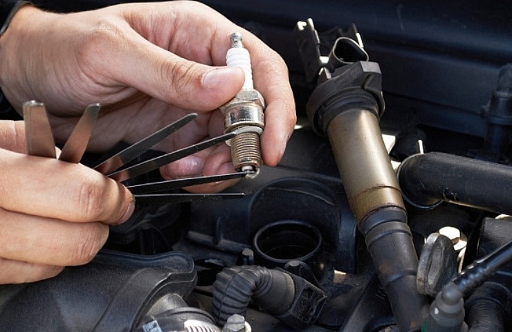 A mechanic gaps a spark plug