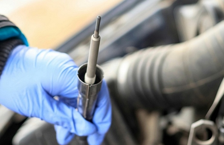 A mechanic inspects a glow plug