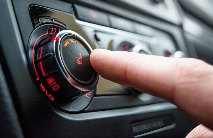 A man presses the button for a heated car seat