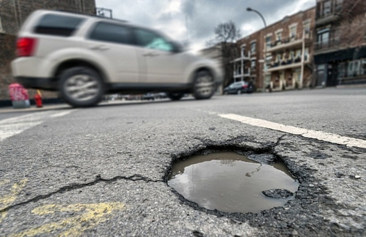 SUV driving past a pothole