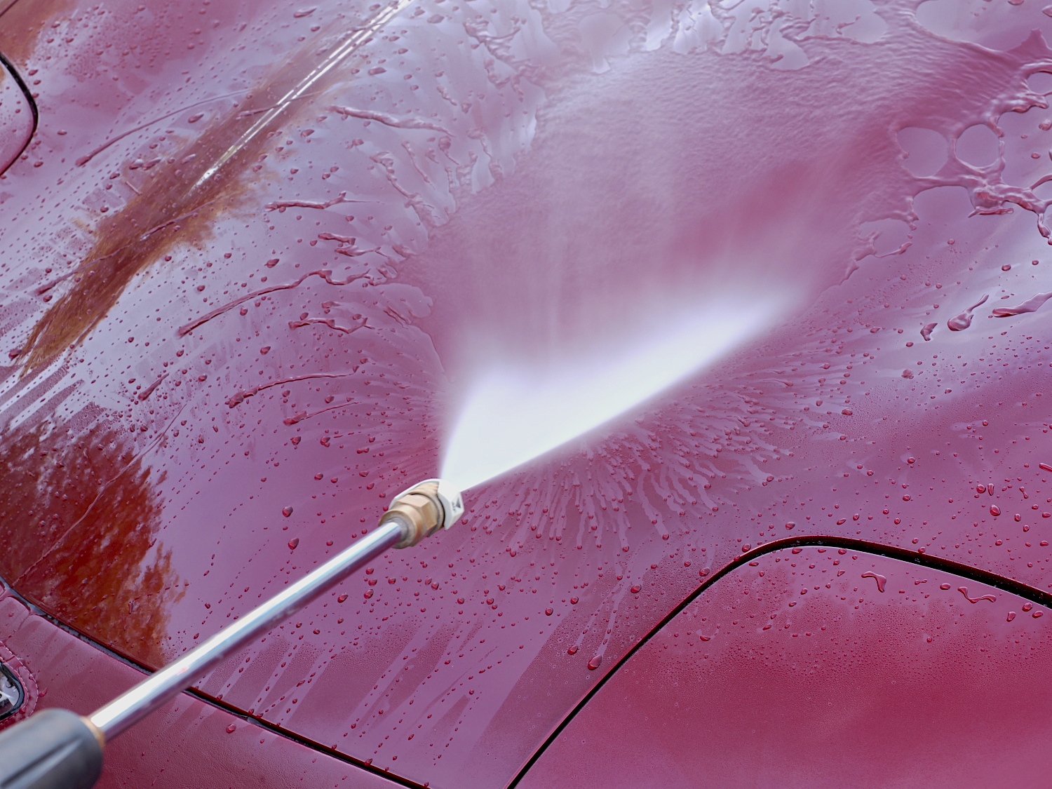 Rinsing the car with a pressure washer