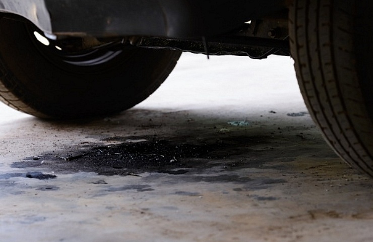 Oil-stained pavement under car - featured