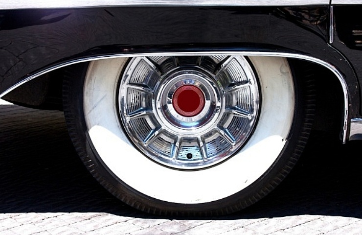 Vintage hubcap on wide whitewall tire with wheel skirt