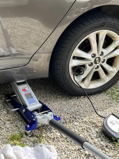 Raising a Kia with a floor jack