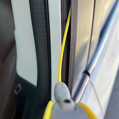A close up view of a a straw-equipped aerosol can lubricating window tracks. 