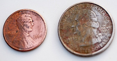Half polished penny and quarter