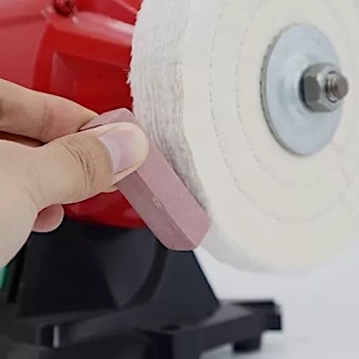 Detailer applying polish to a polishing wheel